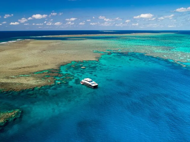 Katamaran vor Anker in den weiten türkisfarbenen Gewässern des Agincourt Reef